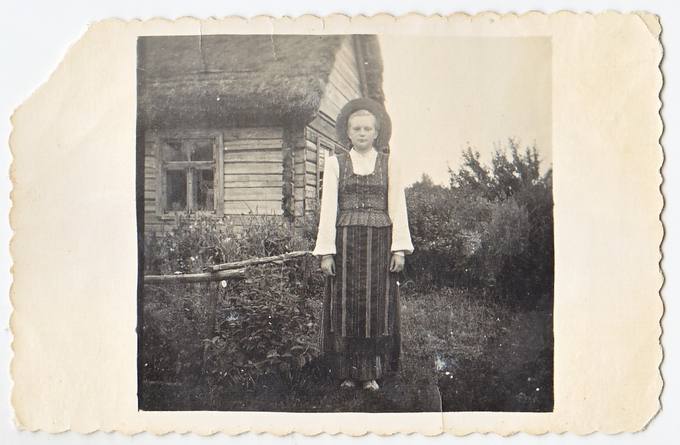 Emilija Petrauskaitė pasipuošusi tautiniais drabužiais savo sodybos kieme Pamiškių kaime